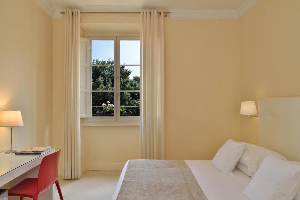 een slaapkamer met een bed, een bureau en een raam bij Residenza Fiorentina in Florence