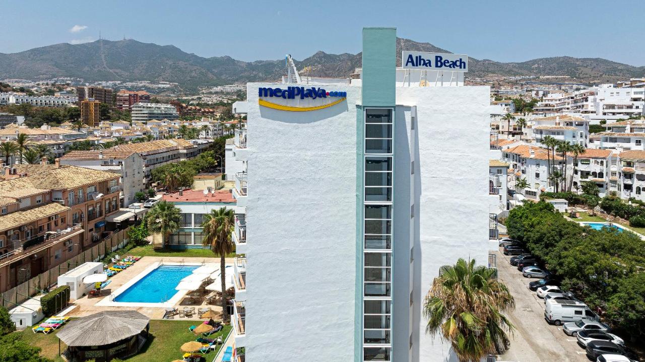 een hoog wit gebouw met een zwembad ervoor, gelegen tegenover een stad bij MedPlaya Hotel Alba Beach in Benalmádena