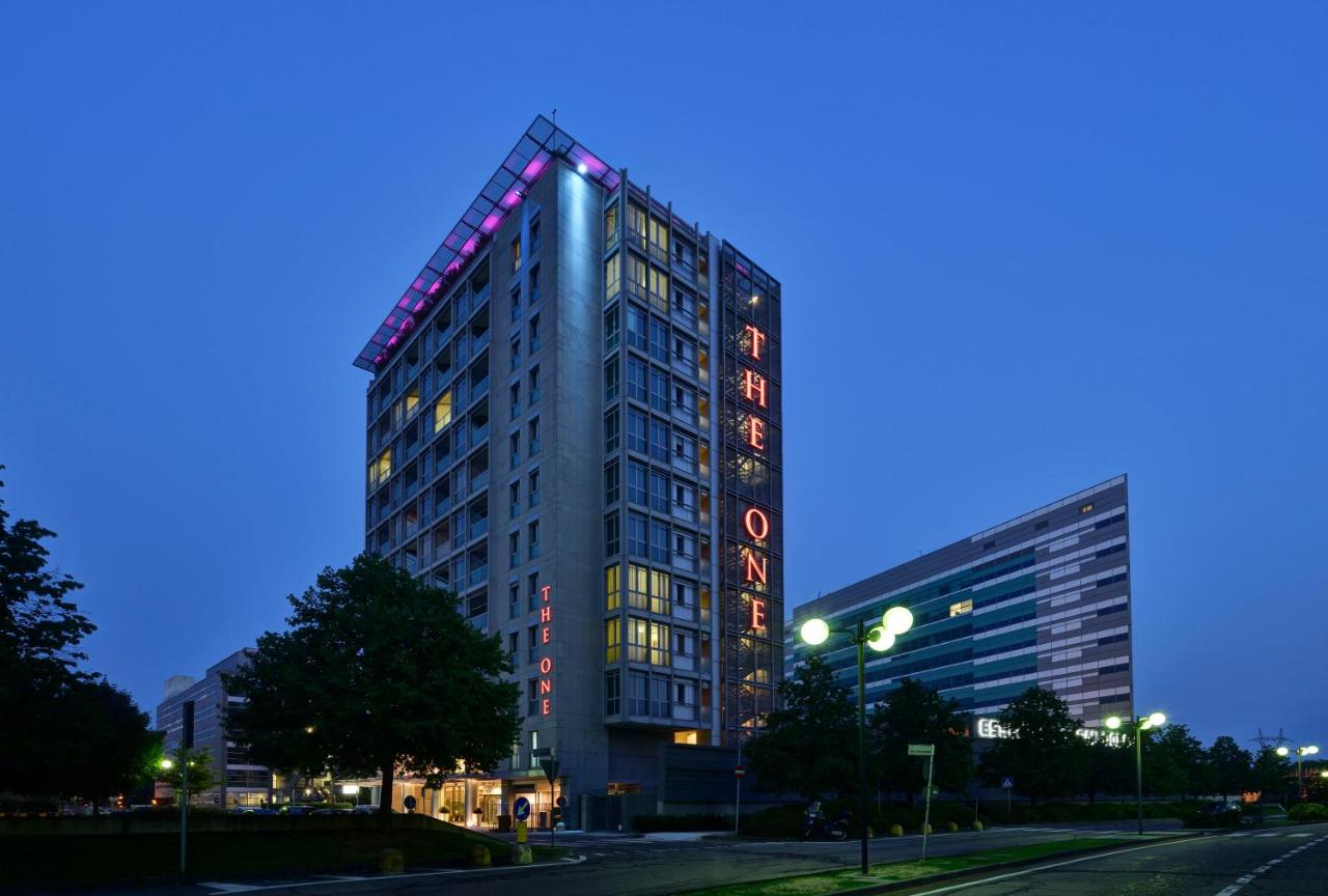 een hoog gebouw met een uithangbord aan de zijkant bij UNA Hotels The One Milano Hotel & Residence in San Donato Milanes