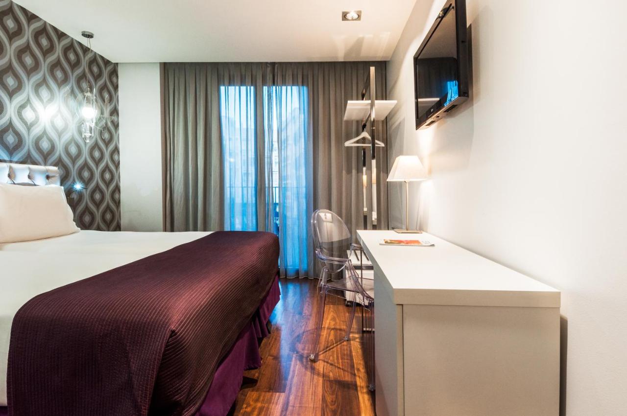 een hotelkamer met een bed en een bureau bij Ikonik Ramblas in Barcelona
