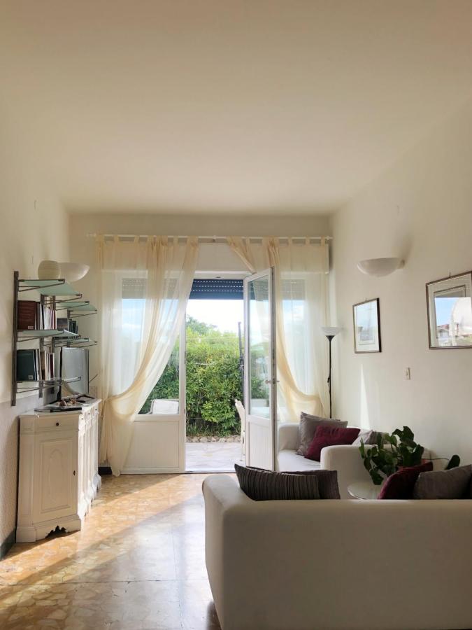 een woonkamer met een witte bank en een schuifdeur van glas bij Hotel Bencista' in Marina di Pietrasanta