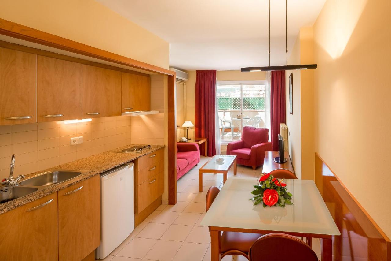 een keuken met een tafel en een woonkamer bij Aparthotel Bertrán in Barcelona