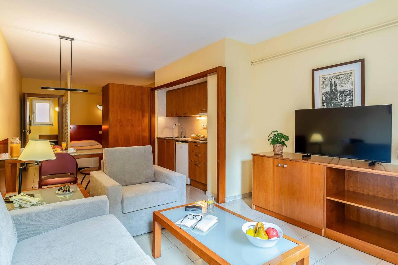 een woonkamer met een bank en een tv bij Aparthotel Bertrán in Barcelona