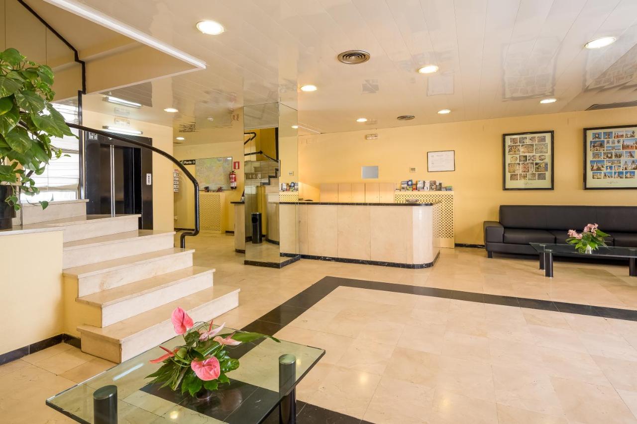 Een lobby van een ziekenhuis met een trap en een balie. bij Aparthotel Bertrán in Barcelona +78 foto's