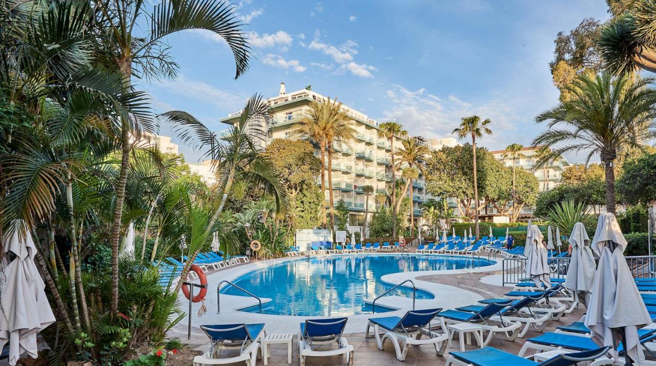 een resortzwembad met ligstoelen en palmbomen bij Palmasol in Benalmádena