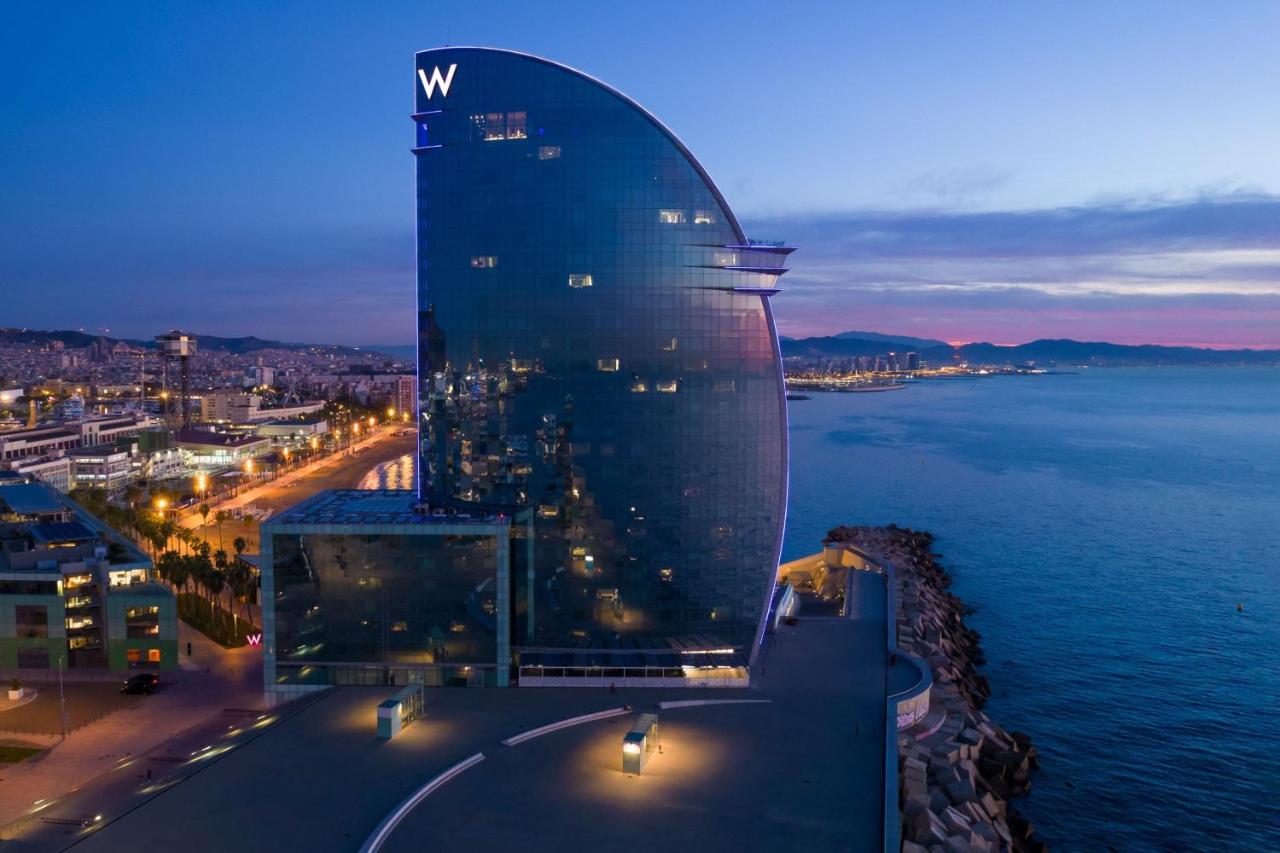 een groot gebouw met een uithangbord erop, vlakbij het water bij W Barcelona in Barcelona