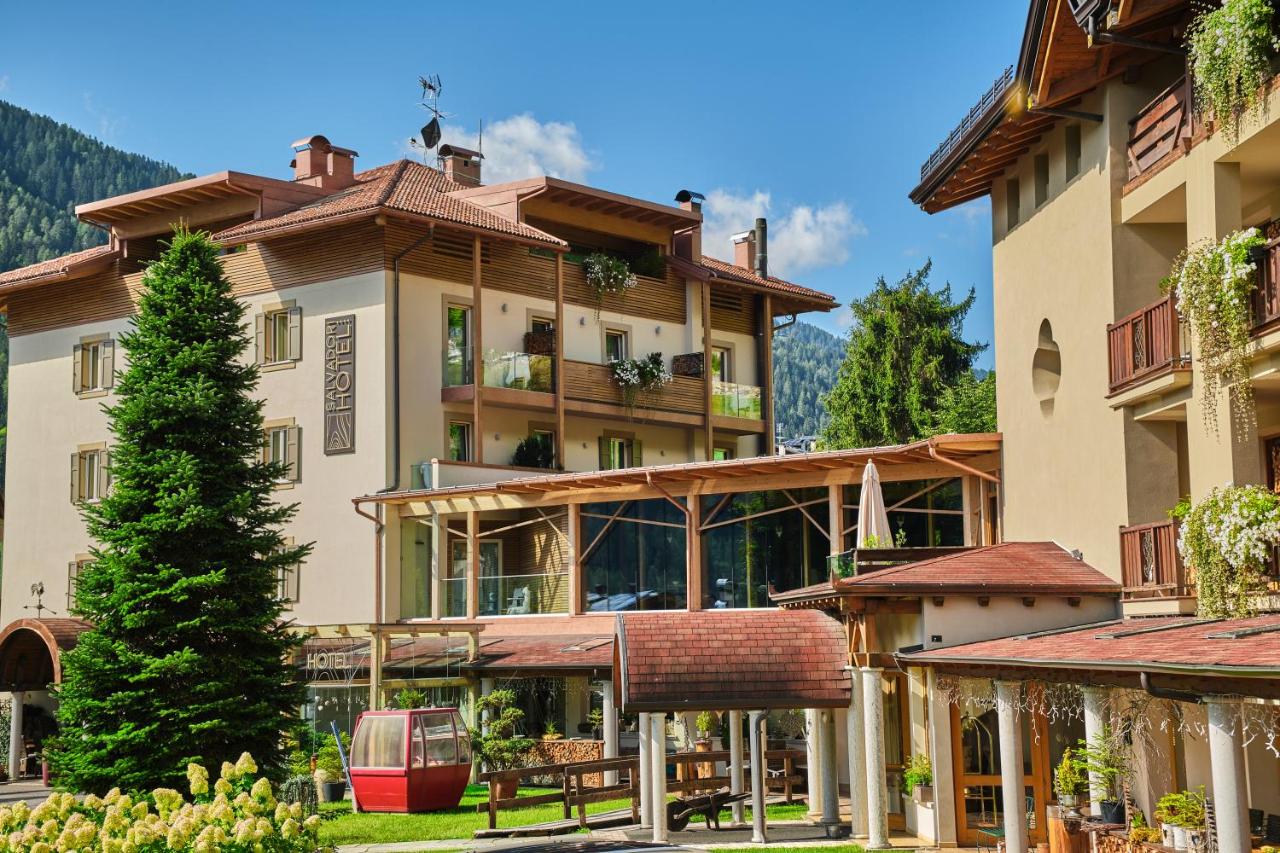 een groot gebouw met veel ramen bij Boutique Hotel e Chalets Salvadori in Mezzana