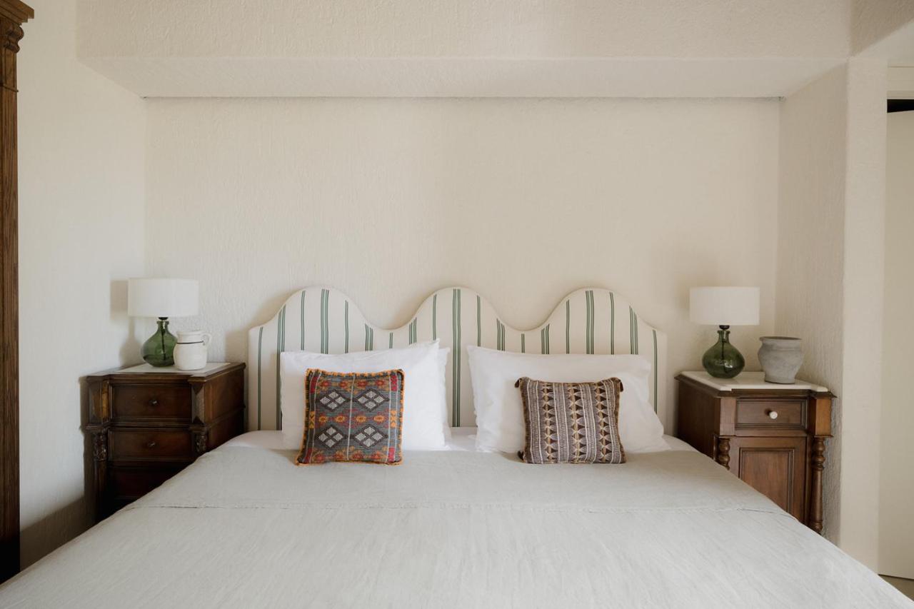 een slaapkamer met een wit bed en twee nachtkastjes bij Koutouloufari Village Holiday Club in Chersonissos