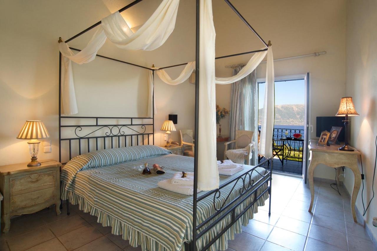 een slaapkamer met een hemelbed en een balkon bij Agnantia Bed & Breakfast in Fiskardho
