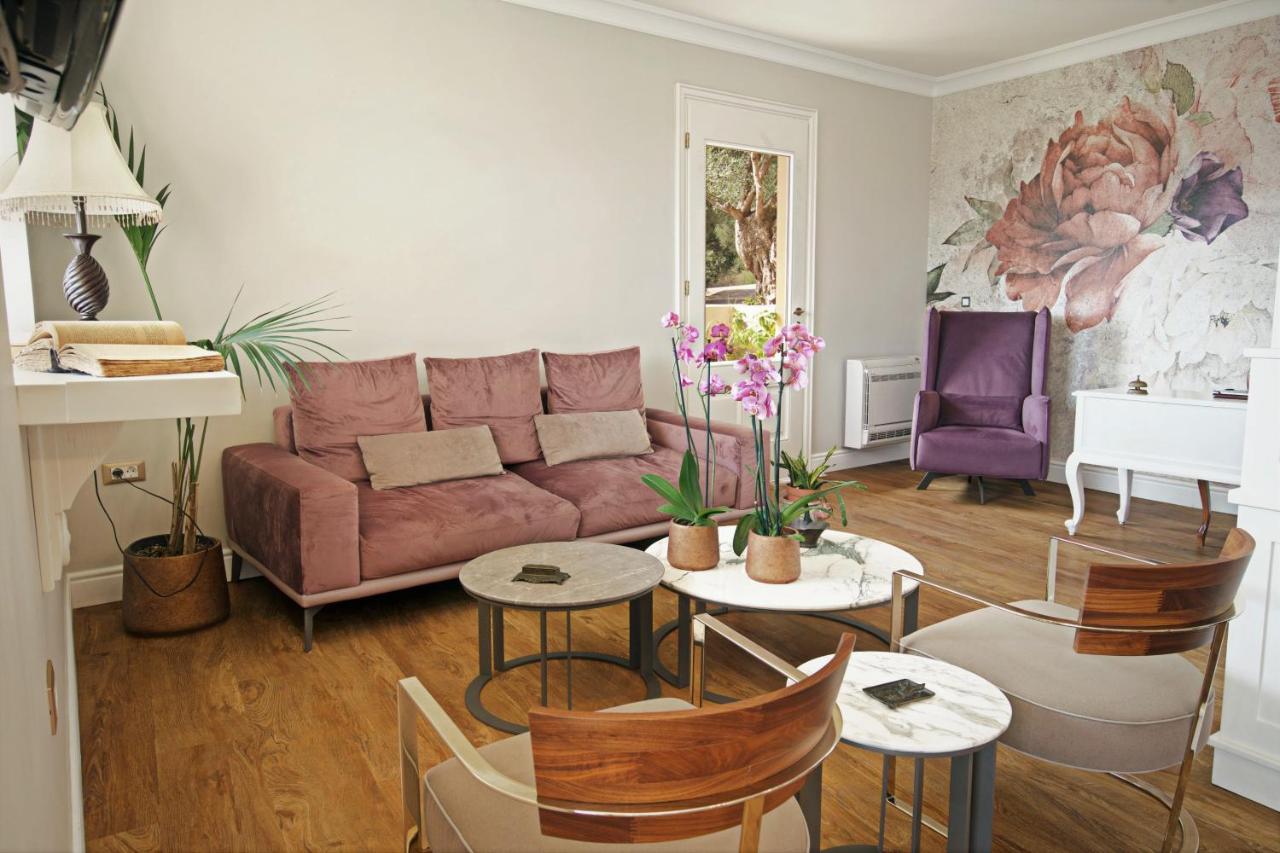 een woonkamer met een bank, tafels en stoelen bij Agnantia Bed & Breakfast in Fiskardho