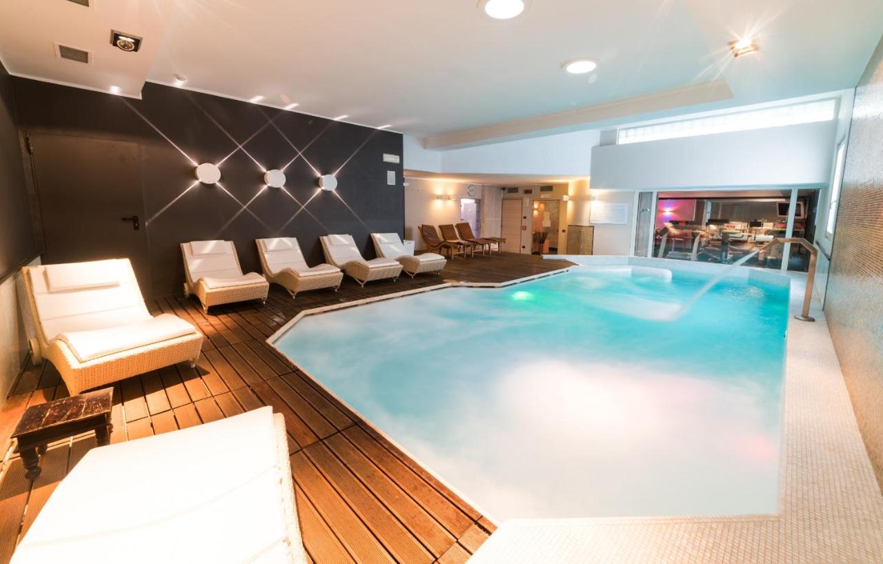 een groot zwembad in een hotelkamer bij Hotel Spinale in Madonna di Campiglio