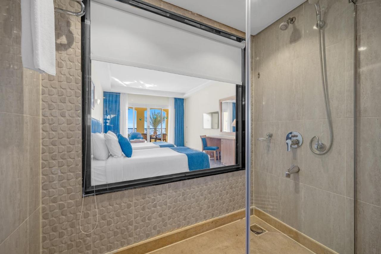 een slaapkamer met een bed, een douche en een spiegel bij Grand Oasis Resort in Sharm El Sheikh