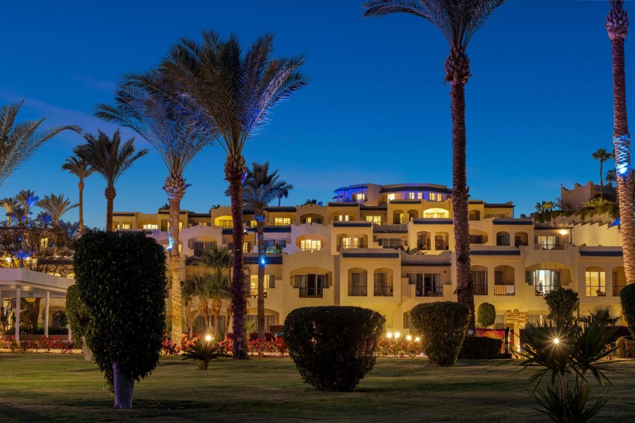 een groot gebouw met palmbomen ervoor bij Grand Oasis Resort in Sharm El Sheikh