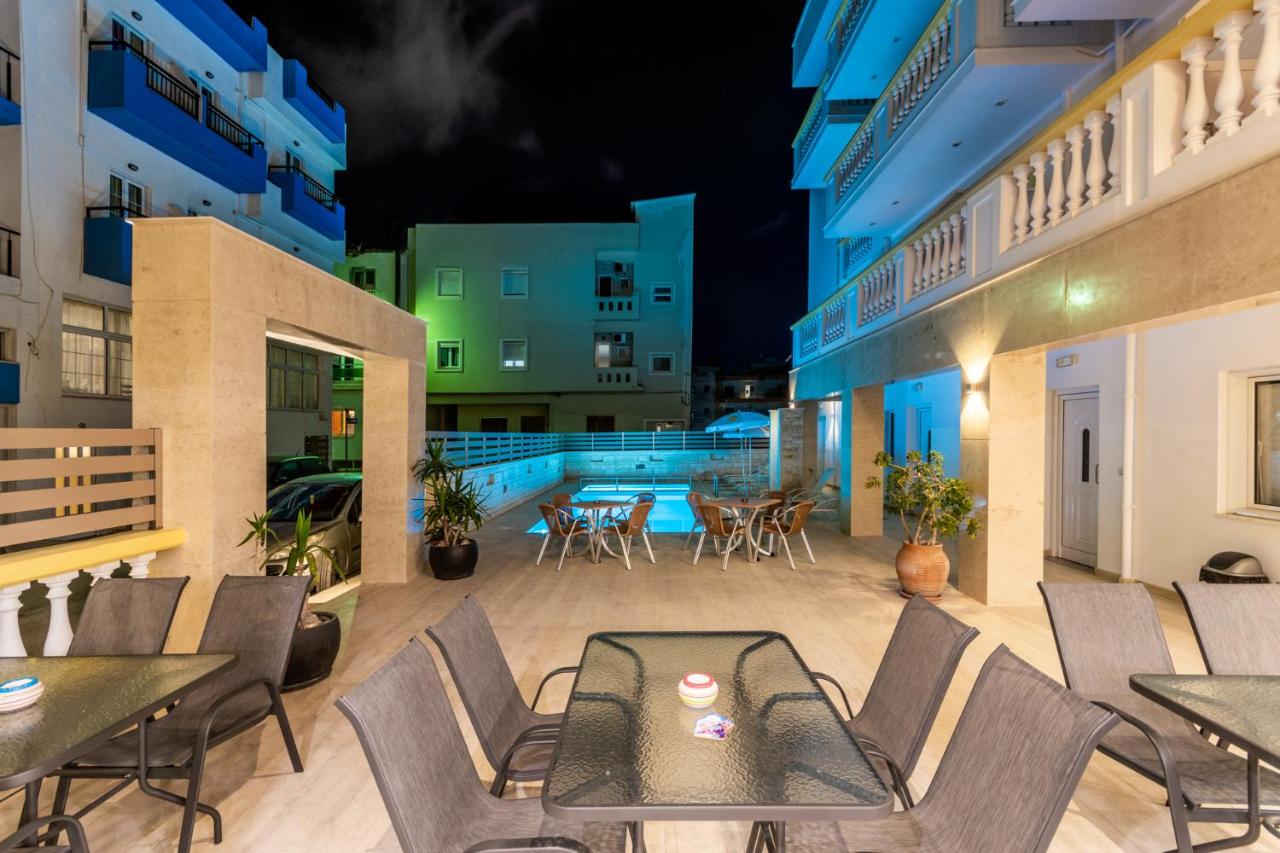 een terras 's avonds met tafels en stoelen bij Irini Apartments in Chersonissos