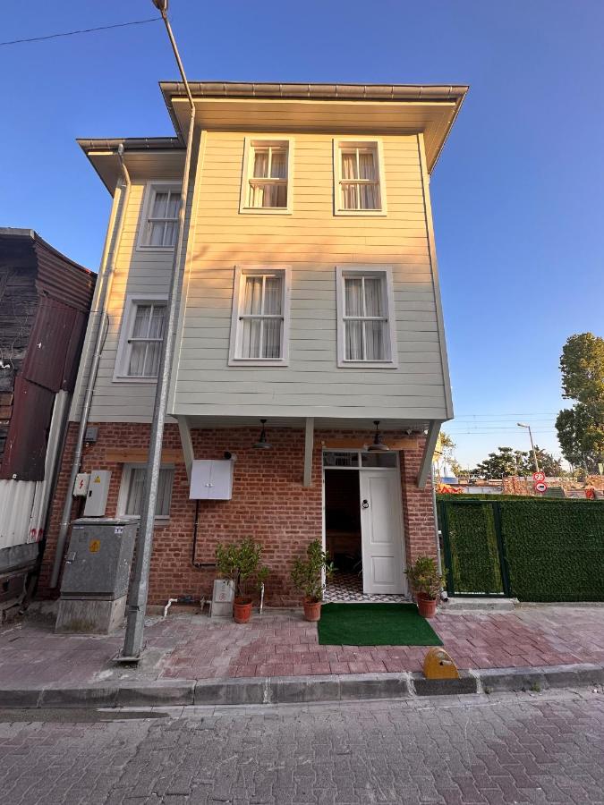 een geel huis met een witte deur aan een straat bij Lovely History in Istanbul