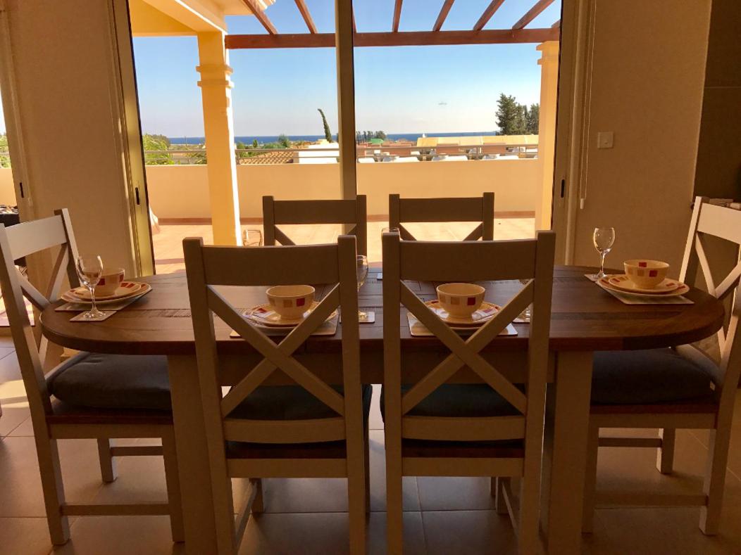 een eettafel met stoelen en een tafel met uitzicht bij Aphrodite Sands Resort - The Penthouse in Mandria