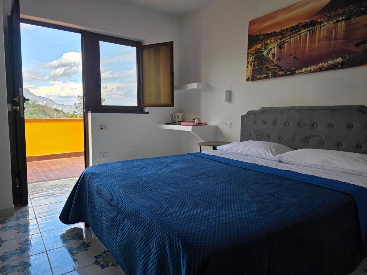 een slaapkamer met een bed met een blauwe deken bij Agriturismo Piccolo Paradiso in Piano di Sorrento