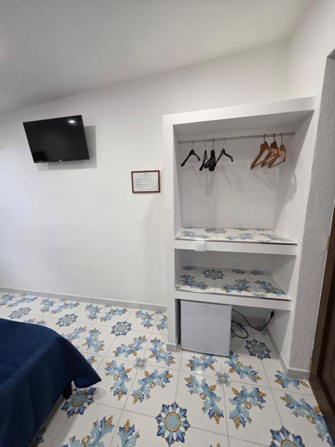 een slaapkamer met een witte muur en een blauw-witte vloer bij Agriturismo Piccolo Paradiso in Piano di Sorrento