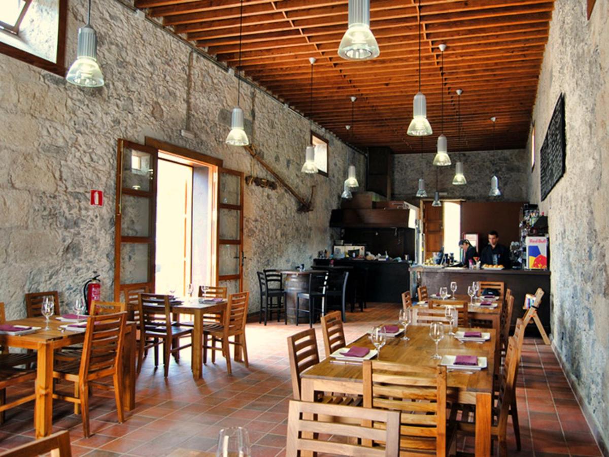 een restaurant met houten tafels en stoelen en een keuken bij Hotel Rural El Mondalón in Las Palmas de Gran Canaria