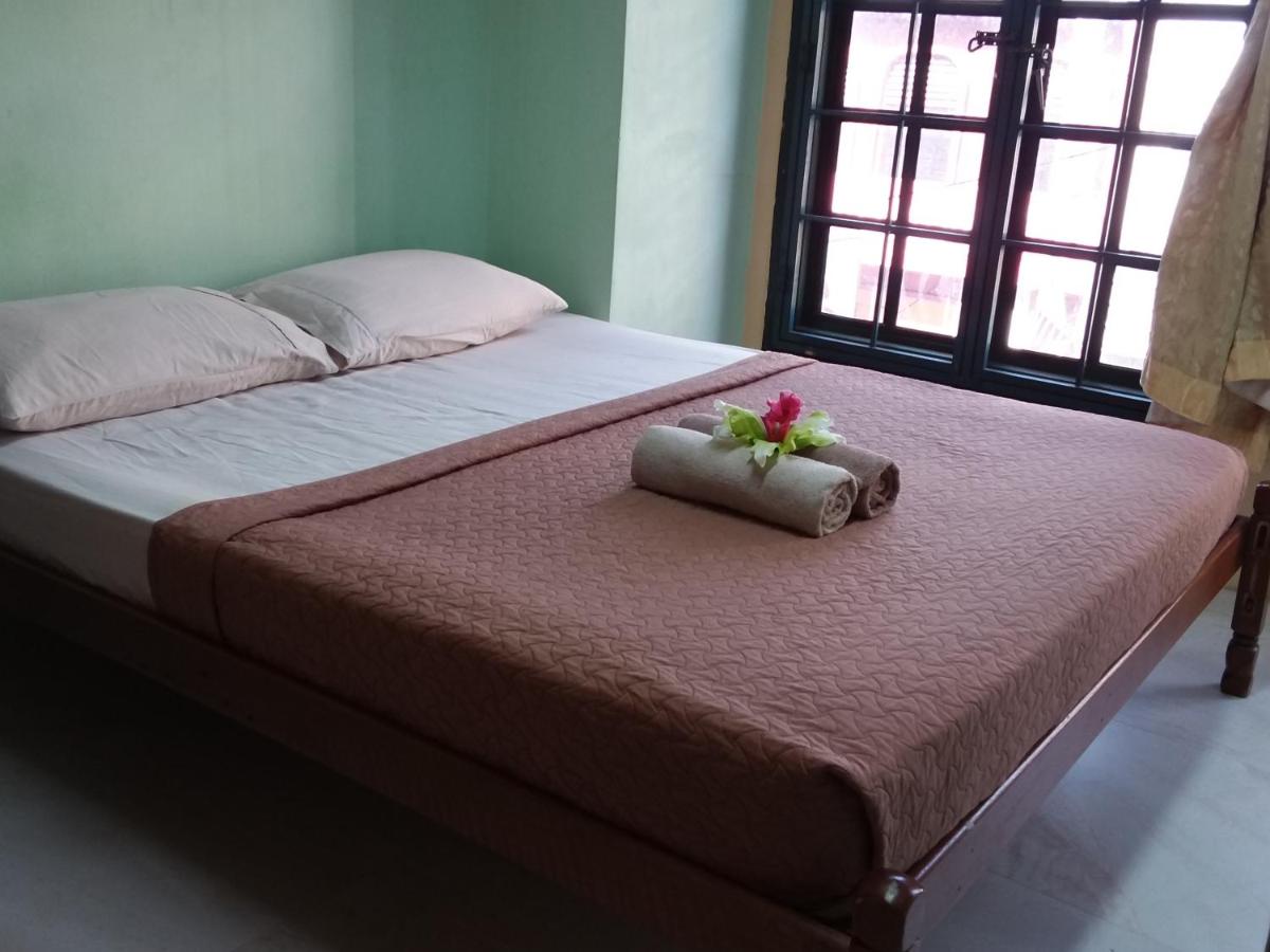 een bed met een kussen met een bloem erop bij Oasis Guest House in Kuala Lumpur