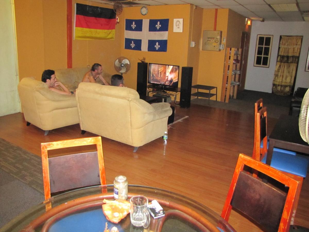 een groep mensen die in een woonkamer tv-kijken bij Oasis Guest House in Kuala Lumpur