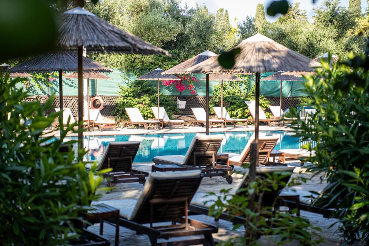 een groep stoelen en parasols naast een zwembad bij Veronica Hotel in Paphos City