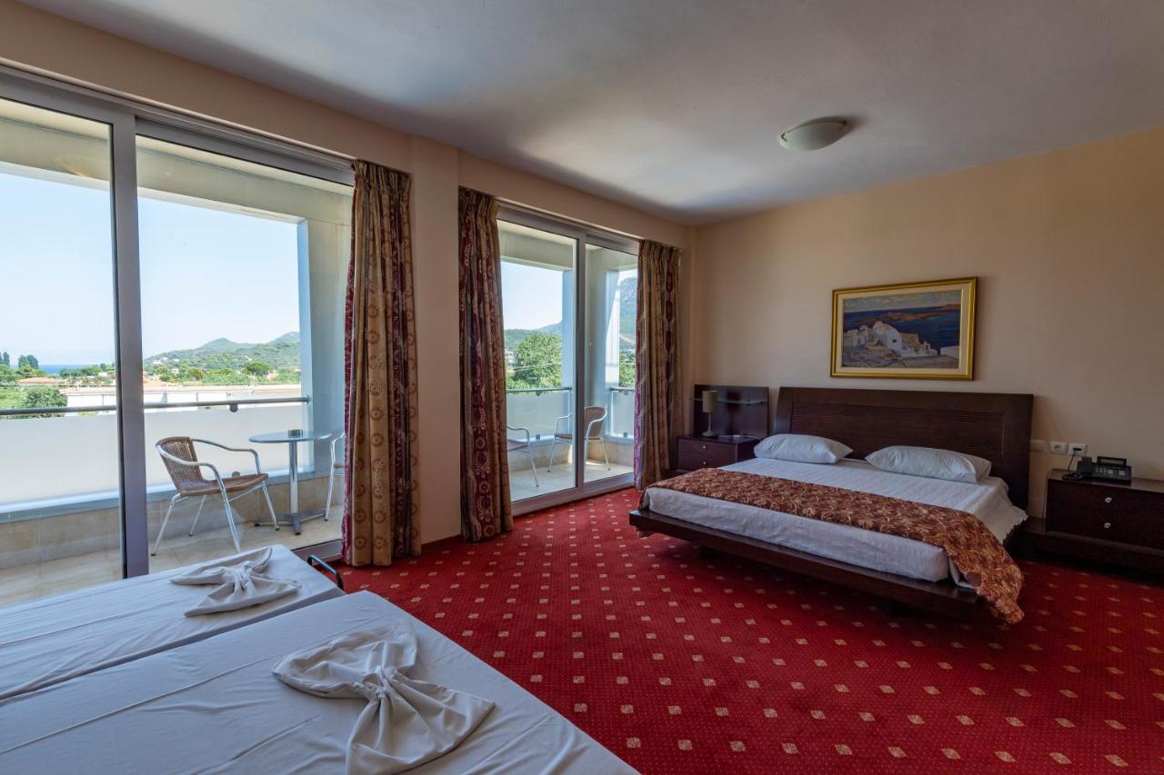 een hotelkamer met twee bedden en een balkon bij Dolphin Resort & Conference in Kalamos