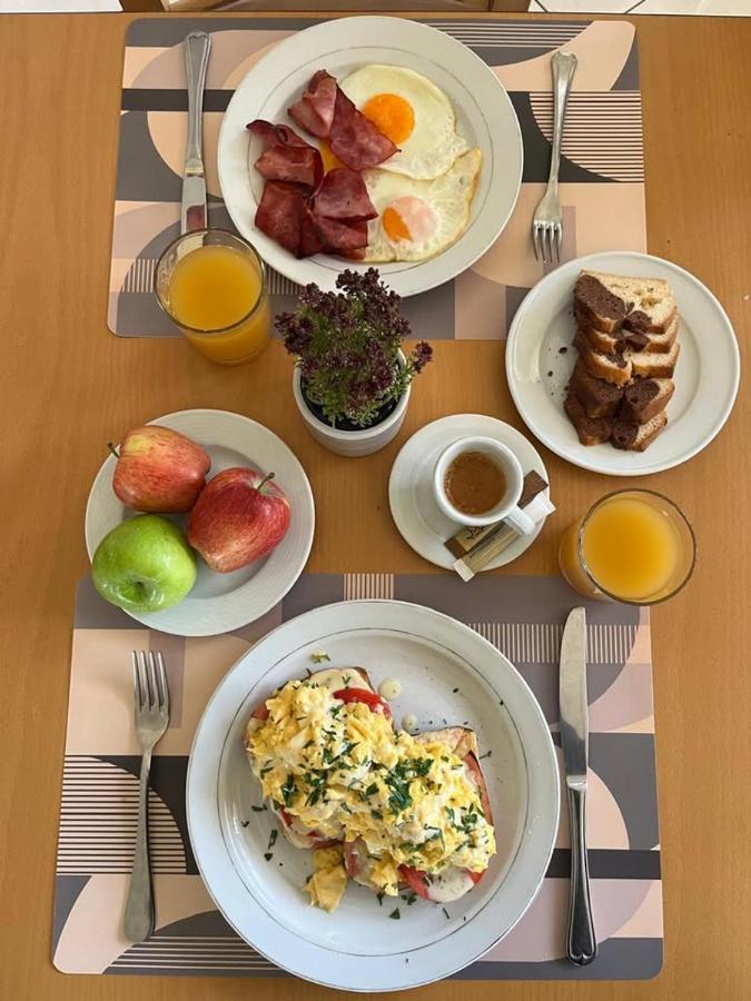 een tafel met borden ontbijt erop bij PARNIS PALACE Hotel Suites in Akharnaí
