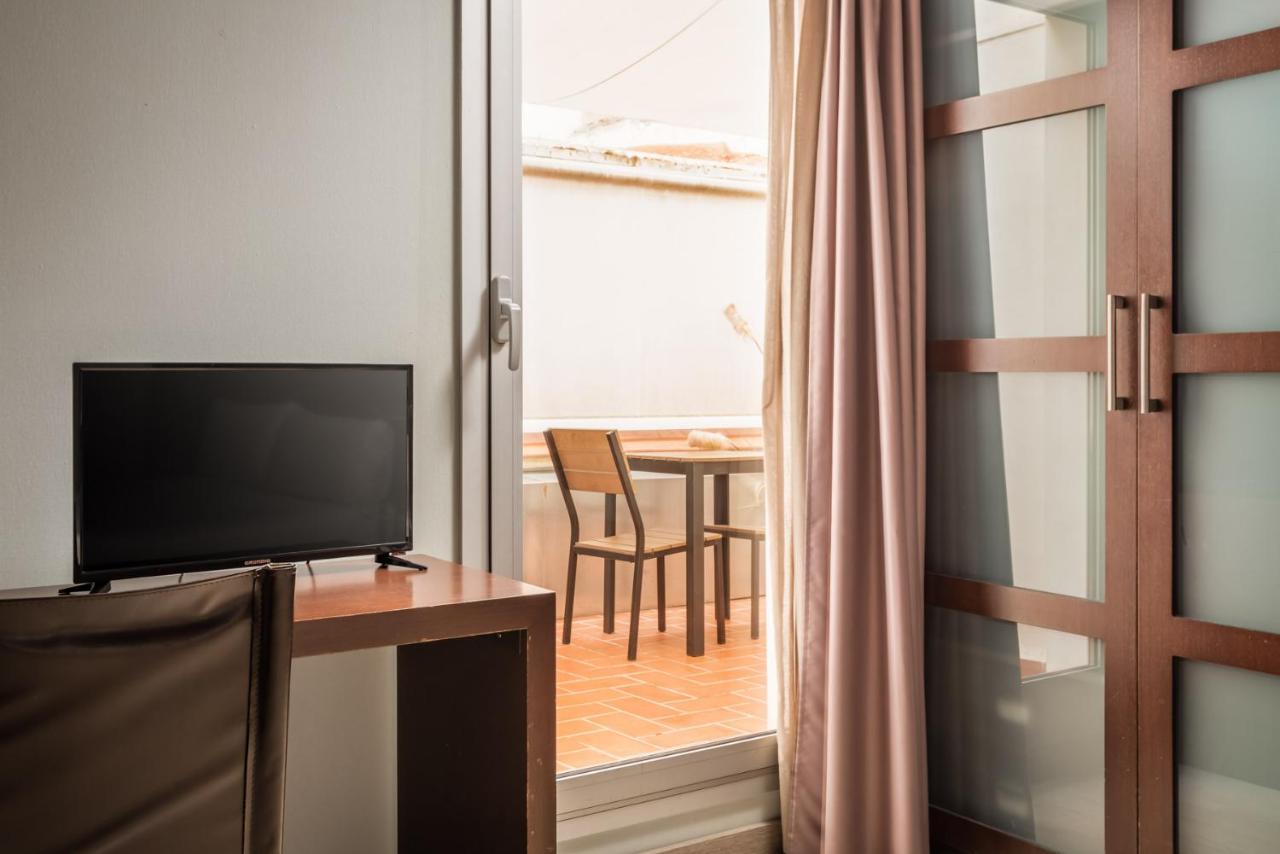 een kamer met een televisie en een tafel met een eettafel bij Hotel Madanis Liceo in Hospitalet de Llobregat