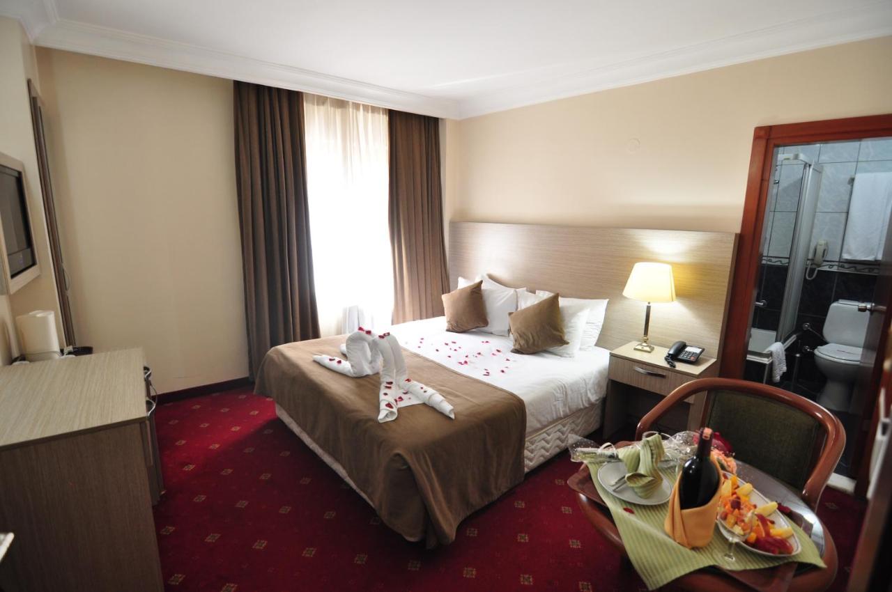 een hotelkamer met een bed en een tafel bij Hotel Buyuk Sahinler in Istanbul