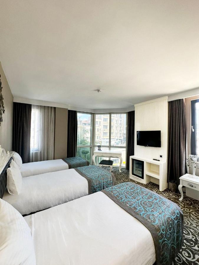 een hotelkamer met twee bedden en een televisie bij Taksim Line Hotel in Istanbul