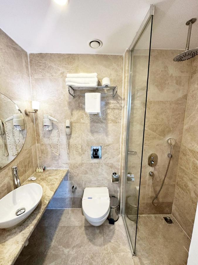 een badkamer met een toilet, wastafel en douche bij Taksim Line Hotel in Istanbul