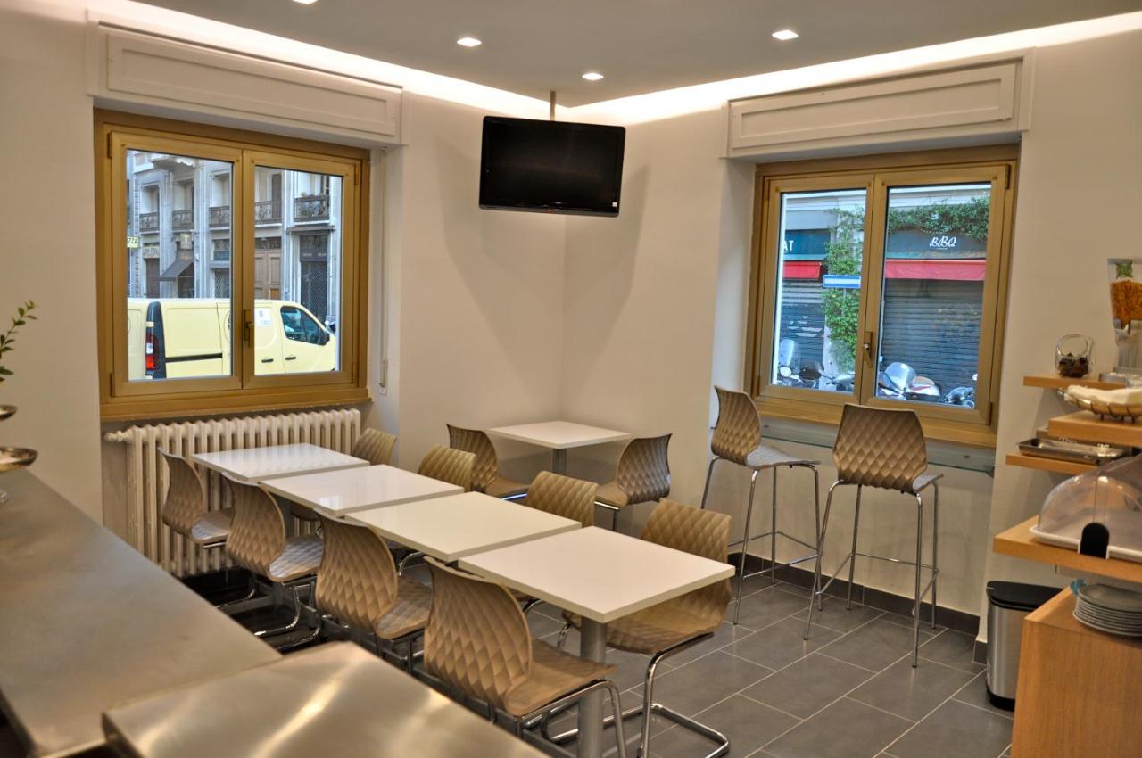 een restaurant met tafels, stoelen en ramen bij Hotel Dover in Milaan
