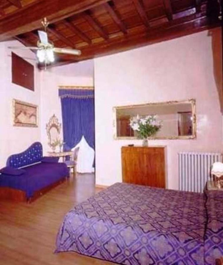 een slaapkamer met een paars bed en een spiegel bij Hotel Abaco in Florence