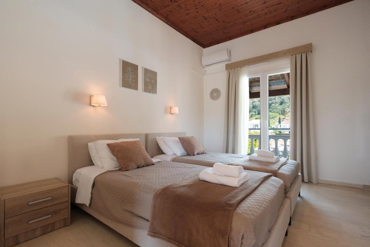 een slaapkamer met twee bedden en een raam bij Katsaros Studios & Apartments in Sidari