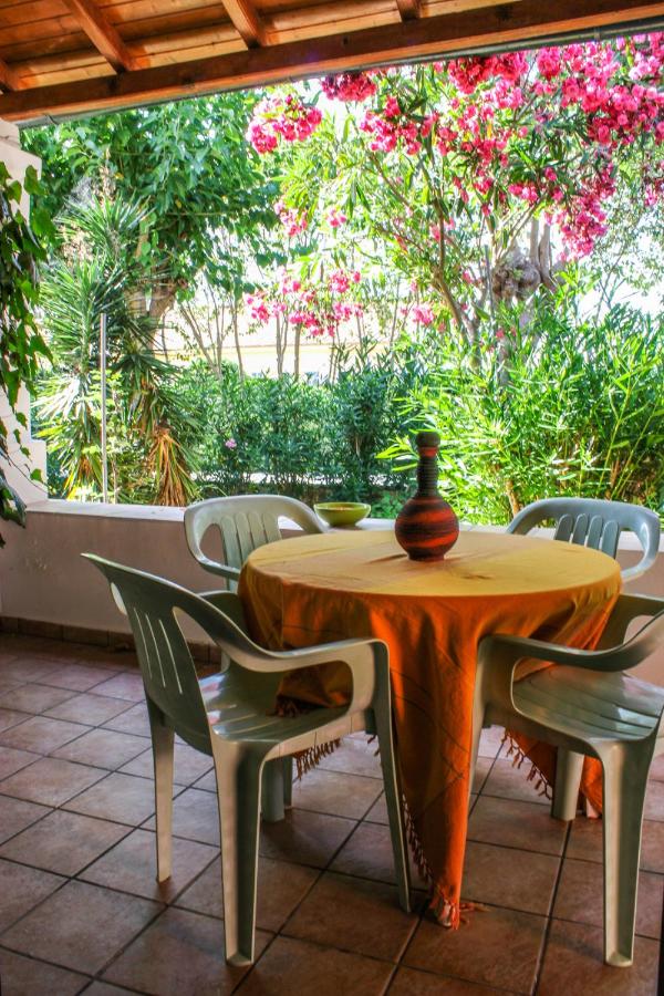 een tafel en stoelen met een vaas erop bij Nireas Resort Corfu in Acharavi