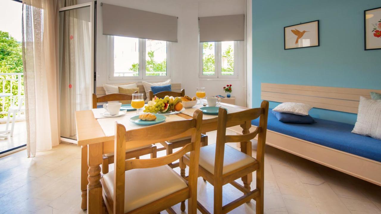 een eetkamer en woonkamer met een tafel en stoelen bij Melissa Apartments, Studios & Suites in Malia