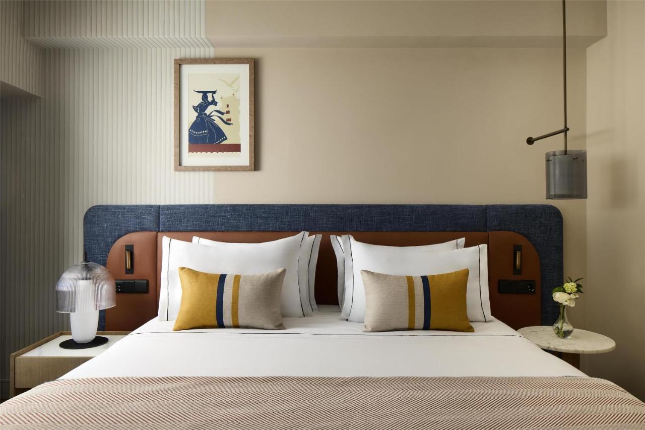 een slaapkamer met een groot bed met een blauw hoofdeinde bij Tivoli Oriente Lisboa Hotel in Lissabon