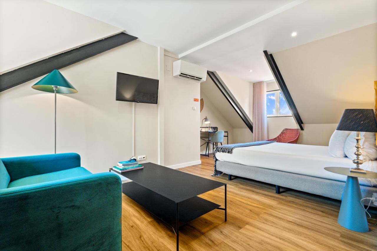 een woonkamer met een bed en een bank bij Casa do Patio by Shiadu in Lissabon