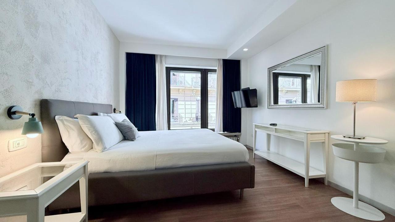 een slaapkamer met een groot bed en een spiegel bij Prestige Rooms Chiaia in Napels