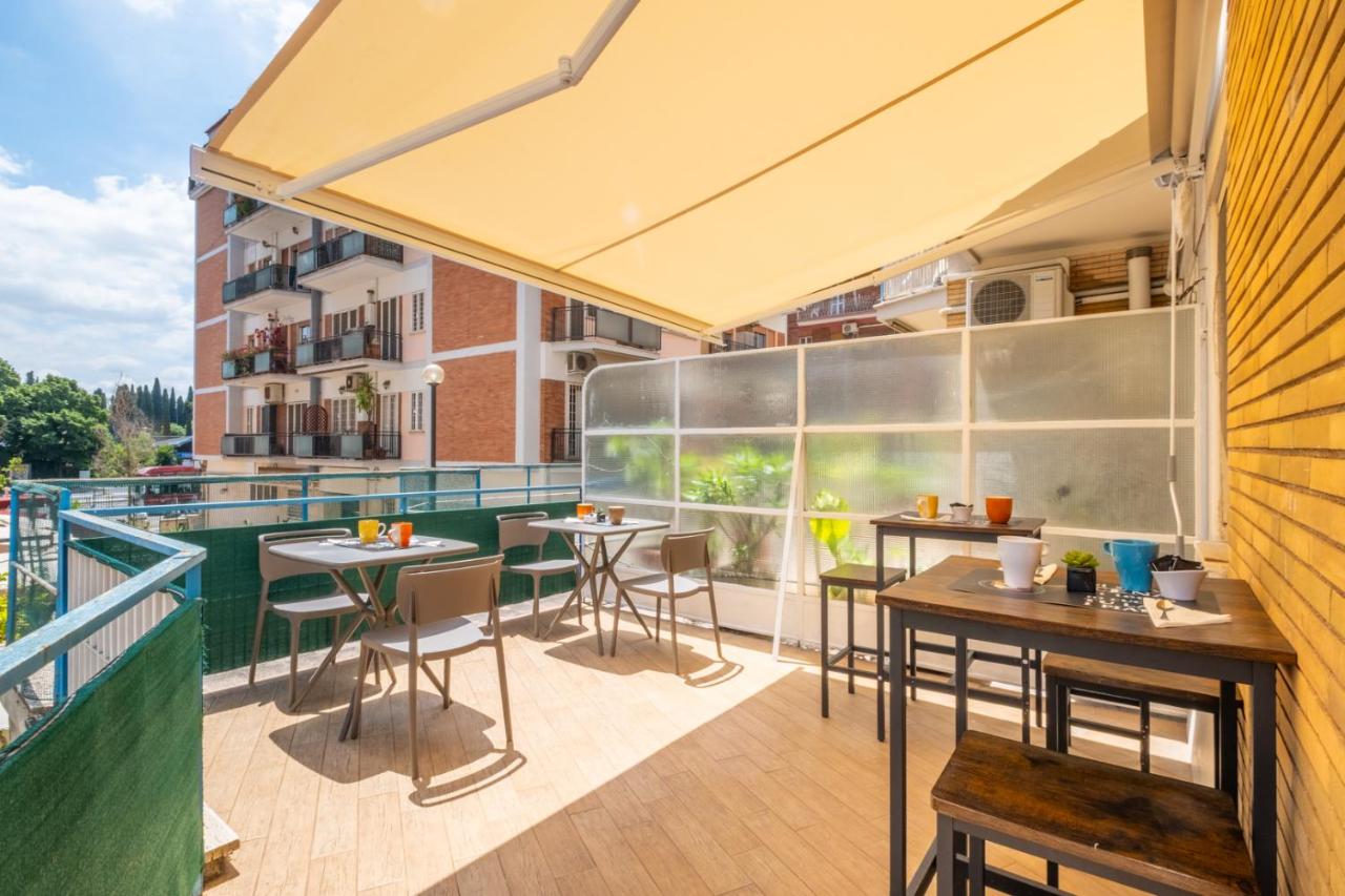 een terras met tafels en stoelen op een balkon bij Relais Tiburtina in Rome +46 foto's