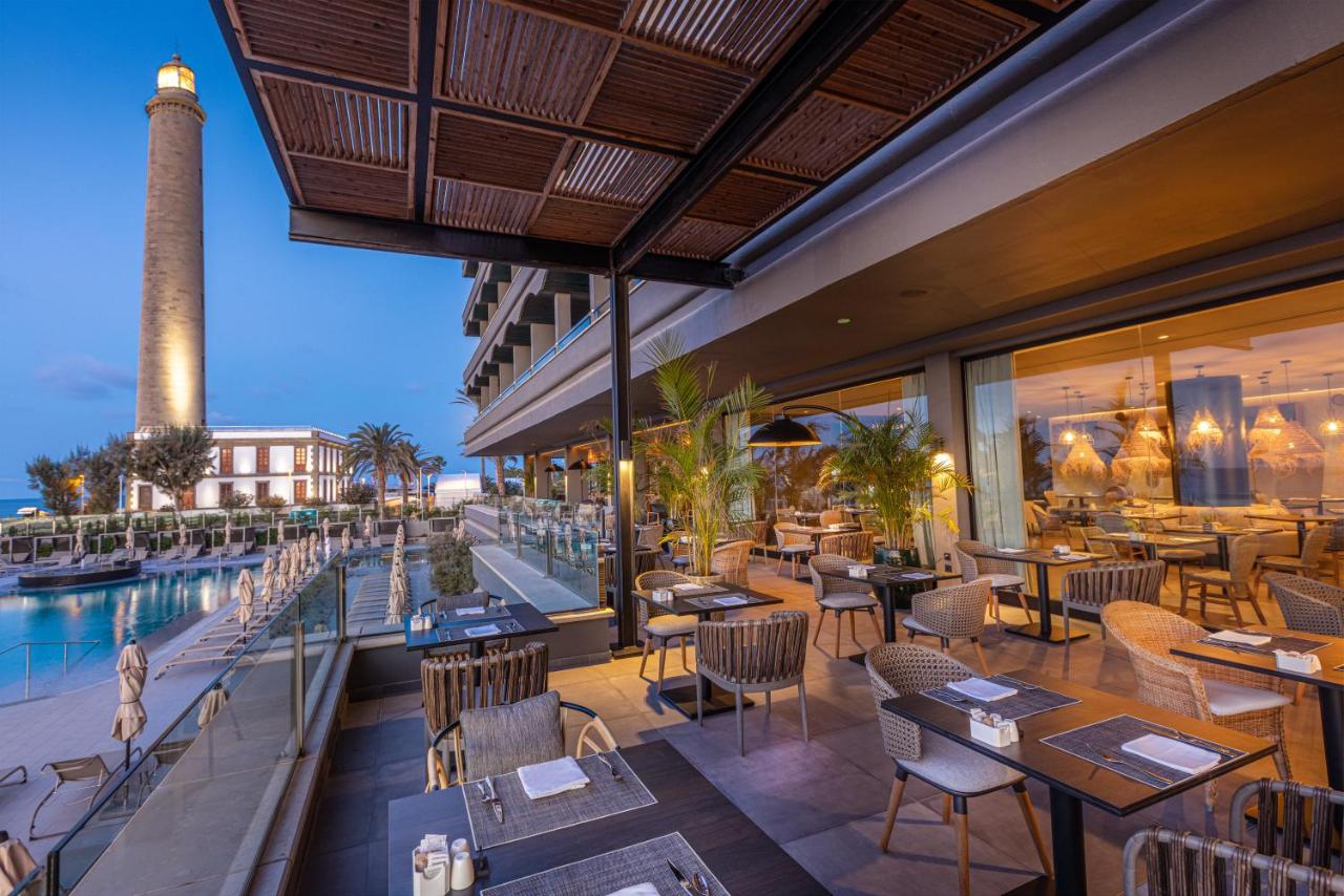 een restaurant met een zwembad en tafels en stoelen bij Hotel Faro, a Lopesan Collection Hotel - Adults Only in Maspalom