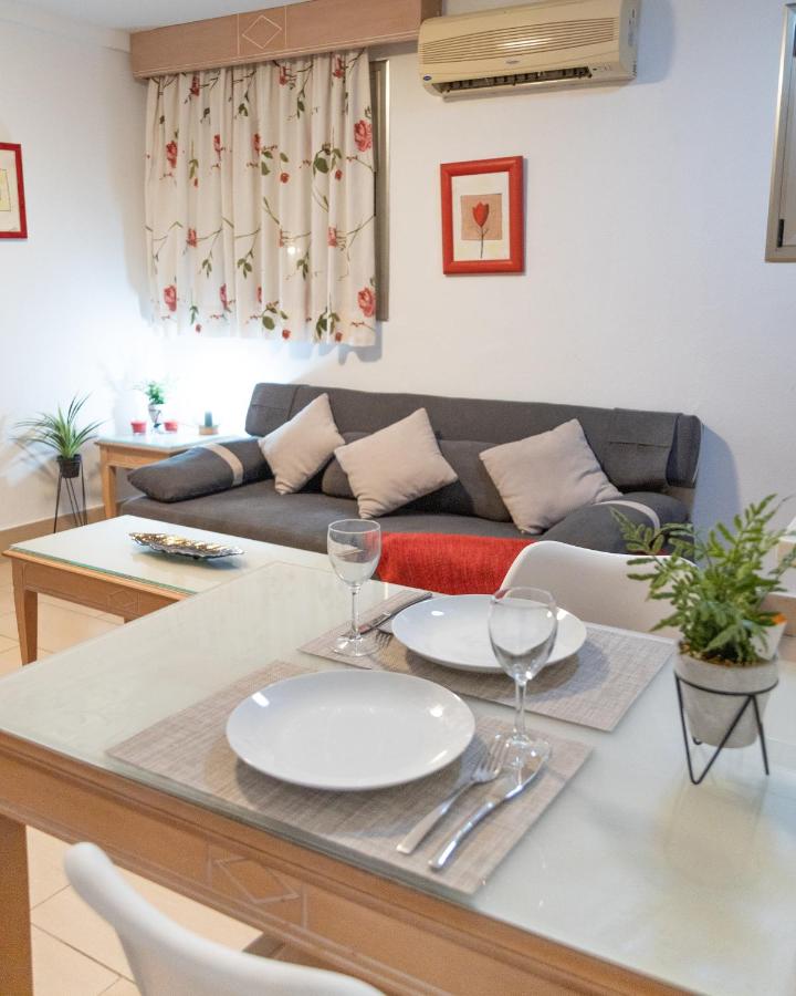 een woonkamer met een tafel met borden en wijnglazen bij Apartamentos Oasis Sol in Maspalomas