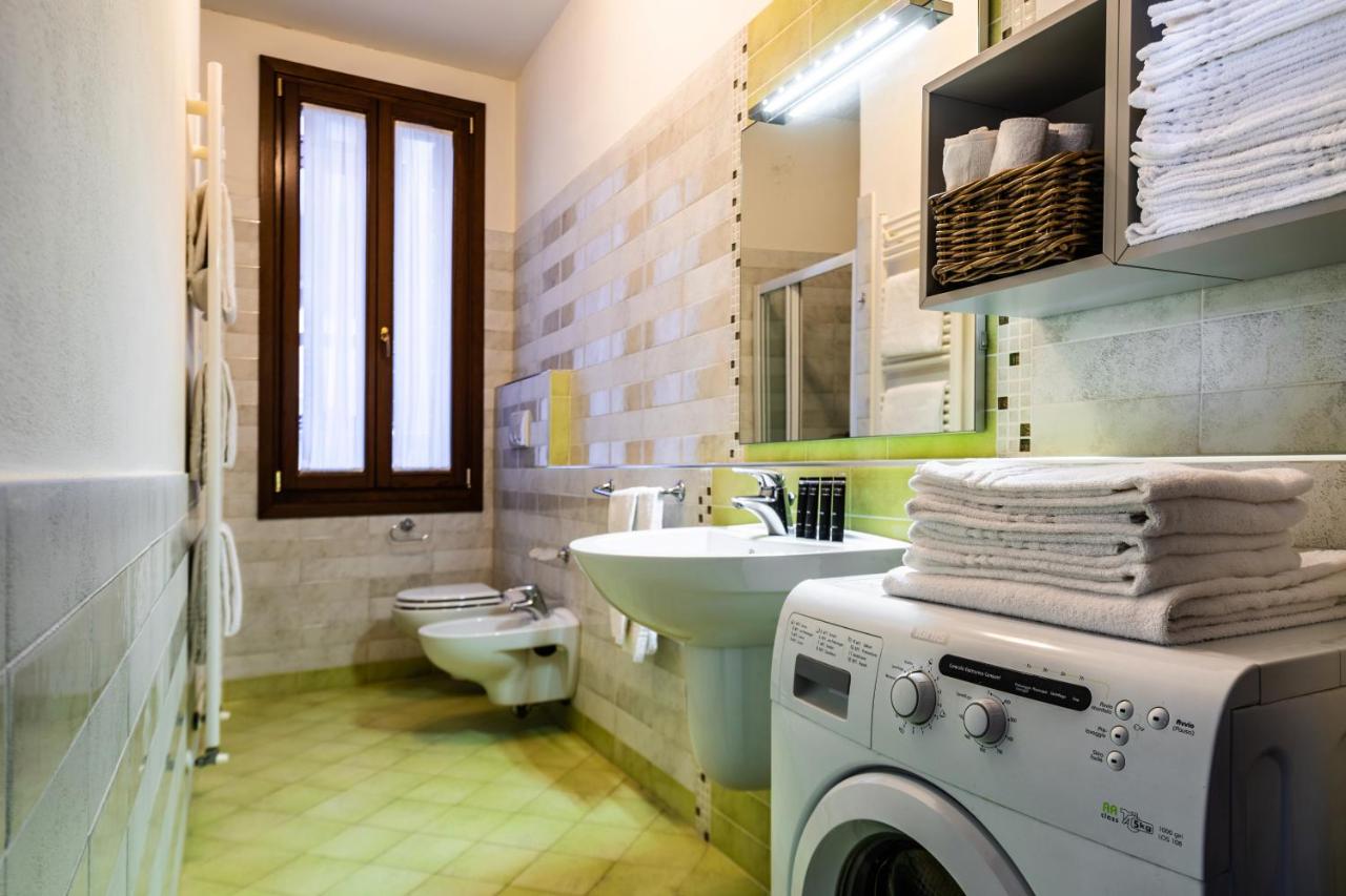een badkamer met een wasmachine en een wastafel bij Cà Sant`Angelo in Venetië