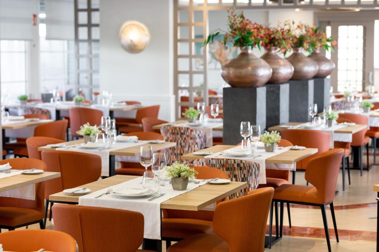 een restaurant met tafels en stoelen en vazen aan de muur bij SOL by Meliá Barbacan in Playa del Inglés