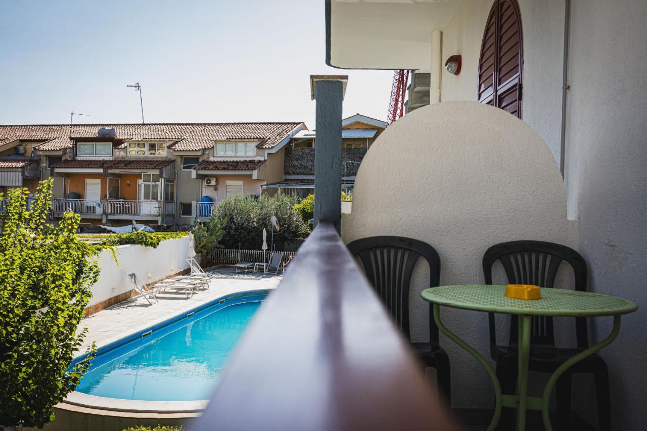 een balkon met een tafel en een zwembad bij Hotel Alexander in Giardini Naxos