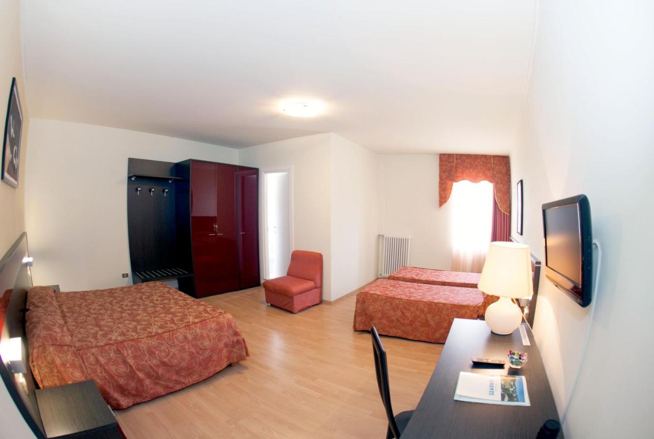 een hotelkamer met twee bedden en een tafel bij Hotel Pinamonte in Costermano