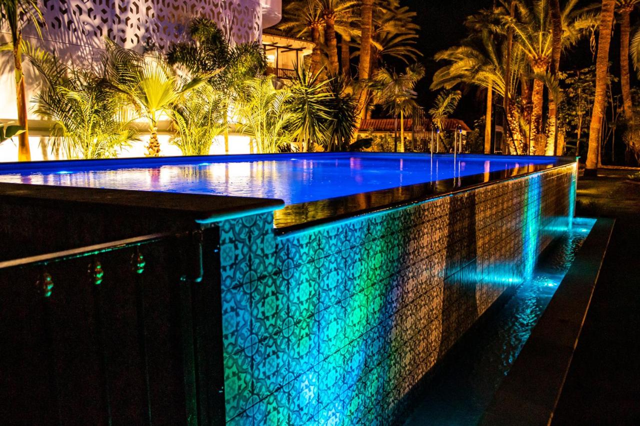 een zwembad 's nachts met blauwe en groene lichten bij Eden Meloneras by TAM Resorts in Maspalomas