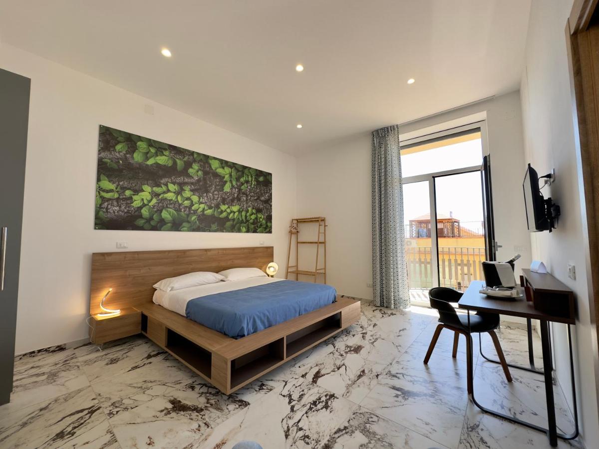een slaapkamer met een bed, een bureau en een raam bij Hotel Exclusive in Agrigento