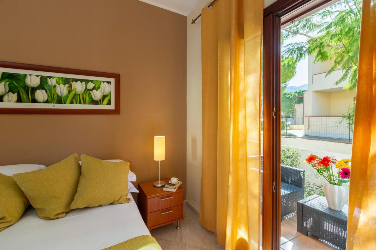 een slaapkamer met een bed en een raam met balkon bij Residence Smeraldo in San Vito lo Capo